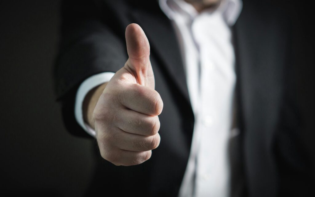 pexels-photo-327533-327533 A close-up of a man's thumbs up gesture, symbolizing success and agreement.